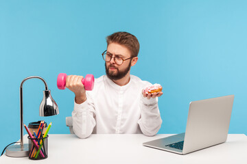 Serious bearded man office worker in eyeglasses and white shirt holding dumbbell in one hand and...