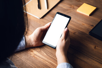 woman holding smart phone on working table