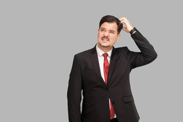 Business strategy and work concept. Puzzlement ceo planning what to say on the board of directors. studio shot, isolated on gray background. handsome businessman with black suit, and mustache.