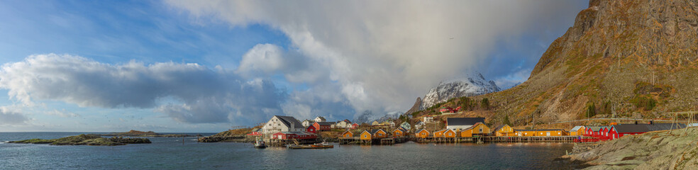 View of the picturesque fishing village of Reine with orange and red rorba in the foreground and mountains in the background, Lofoten Islands, Norway.