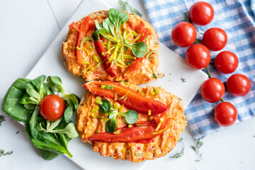 vegan roasted red pepper dip sandwich spread on freshly baked bread slice with salad garnish on white porcelain plate 