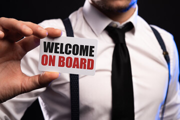 Welcome on board - Businessman holding white sign with text in the office