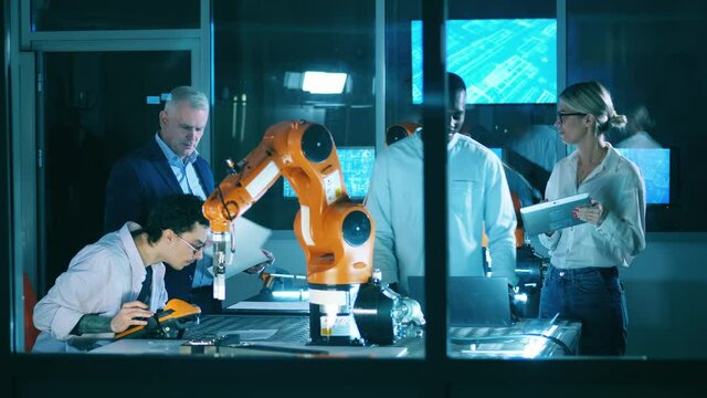 Group of scientists are working on a robotics project. Professional engineers working with innovative equipment, teamwork concept.