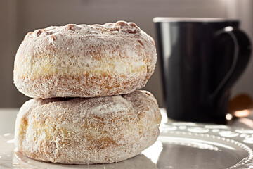 Two Donuts Stacked on white plate and black mug