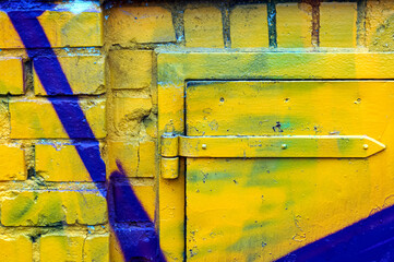 Background yellow painted metal door on a house facade or wall