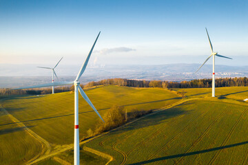 Panoramic view of wind farm or wind park, with high wind turbines for generation electricity with...