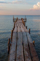 Wooden empty pier by the calm sea at sunset