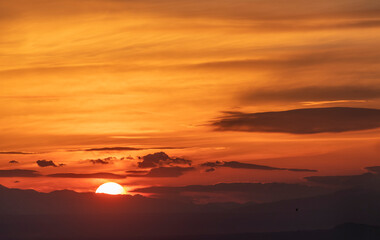 Fototapeta na wymiar A huge sun sets over the horizon. Beautiful bright sunset sky. Nature, sunset background. 