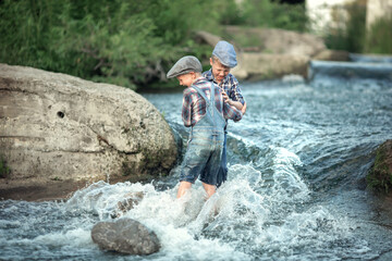 two gay brothers in jeans and shirts with caps on their heads are in the in the river over and hug