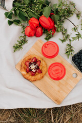 sweet bun and flowers on a white plaid, summer picnic on the grass