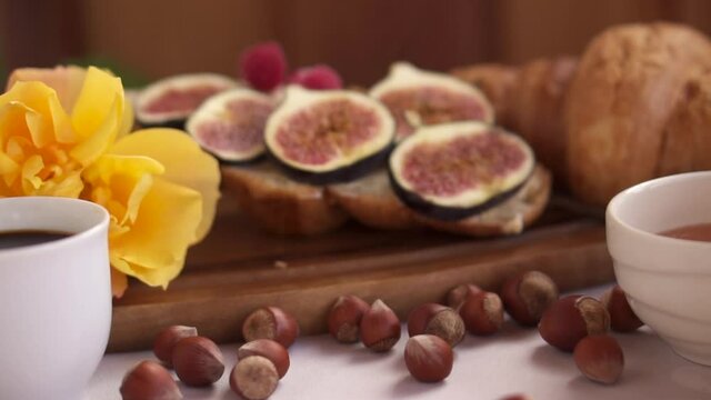 Coffee and croissant for Breakfast. French toast with figs near a yellow rose. High quality photo