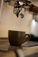 espresso coffee pouring into ceramic cup, closeup