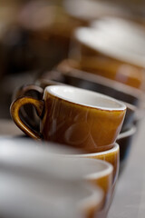 bunch of brown Loveramics ceramic coffee cups on top of espresso machine