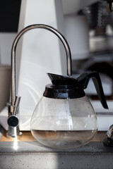 empty glass filter coffee pot filling with water, closeup