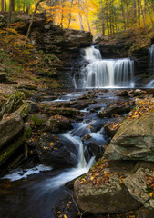  colorful autumn foliage with calming cascading waterfall in Pennsylvania.