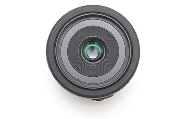 A small thin black 24 mm lens for a dSLR camera without a name lying on a white background without covers. Close-up top view