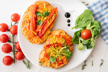 vegan roasted red pepper dip sandwich spread on freshly baked bread slice with salad garnish on white porcelain plate 