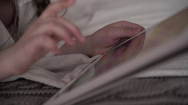 baby girl playing a game on the imobile tablet. having fun on vacation at home close-up. High quality 4k footage