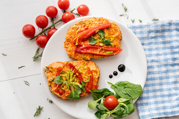 vegan roasted red pepper dip sandwich spread on freshly baked bread slice with salad garnish on white porcelain plate 