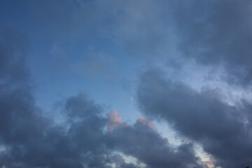 Fototapeta premium Dreamy, fairy tail like, blue and purple clouds on a sunset sky with bright moon