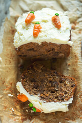 Carrot cake with rising and candied lemon,  icing and decorated with little marzipan carrots 