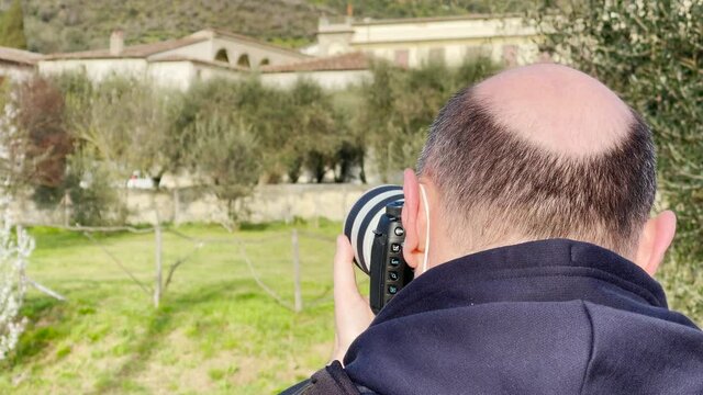 Photographer with white camera taking pictures of natural landscape in slow motion