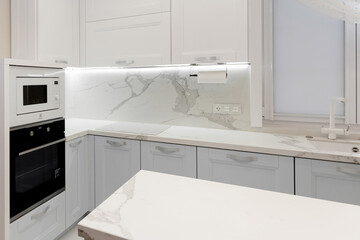 Bright white kitchen countertop. Grey facade doors.