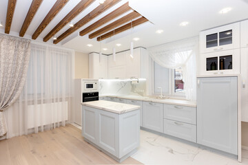 Beautiful corner of white kitchen with grey doors, appliances and countertop