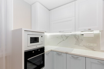 Beautiful white kitchen with grey doors, countertop and  appliances.