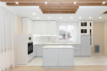 White kitchen, grey doors, countertop. Wooden ceiling.