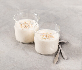 Italian dessert oatmeal Panna Cotta in a glass on a light gray background