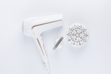 Hairdryer for drying hair with a diffuse and flat nozzle for styling on a white background