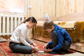 Fototapeta premium Children playing with blocks on the floor - focus on the boy's face