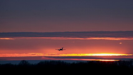 An airplane lands against the background of the evening sky at sunset

