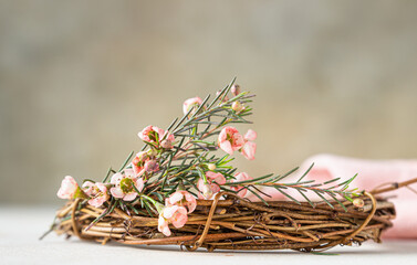 Detail of a decorative spring wreath made of twigs and flowers. DIY creativity. Close up.