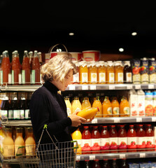 Young man shopping in supermarket, reading product information.