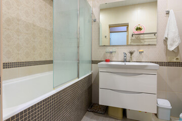 Bathroom interior, the bathroom is separated from the washbasin by a glass partition