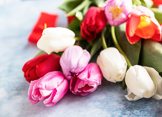 Colorful tulips on a blue concrete background. Spring flowers. Top view. Close up.