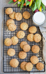 Oatmeal cookies on black metal grille, wooden background. Healthy vegan cookies. Top view.