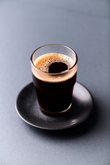 Coffee in glass cup on gray background. Close up.