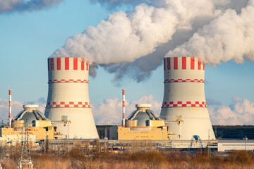 Nuclear power plant cooling towers emissions of steam in the air atmosphere. Industrial zone