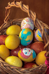 Easter wooden basket filled with colorful painted eggs. Warm background.
