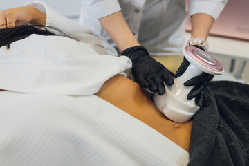 Woman in special white suit getting anti cellulite massage in a spa salon. LPG, and body contouring...