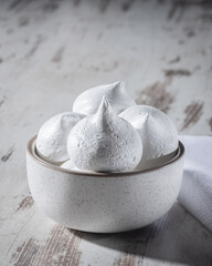 Homemade white meringue cookies dessert in bowl on the table