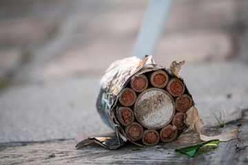 Used fireworks firecrackers lying on ground after exploding in celebration. Fireworks boxes after celebrating New Year and Christmas. Visible tubes and debris.