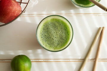 Green juice with bamboo straws in the background - zero-waste or ecology concept