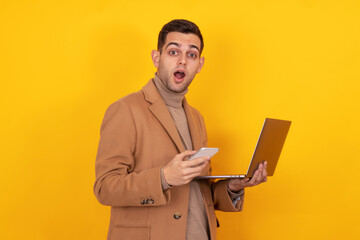 young man with smartphone and laptop isolated on background