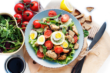 Salad with mussels, tomatoes, eggs, arugula, spinach, lemon and croutons on white background. Seafood salad with vine sauce. Top view