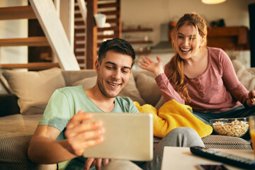 Happy couple having video call over touchpad at home.