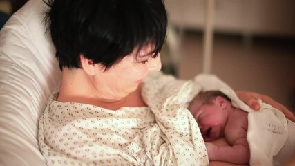 Establishing table emotional connection. A woman holds baby girl on her stomach. Calms and relaxes both mom and baby. Life adaptation stimulates digestion and interest in feeding.